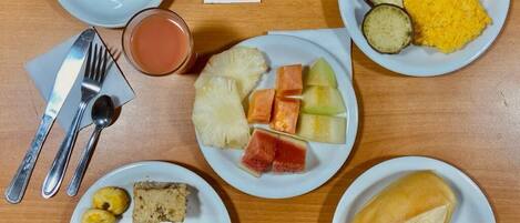 Una mesa de desayuno con tostadas, fruta y huevos.