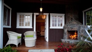 An outdoor seating area with wicker chairs and a stone fireplace. - Hotel Finca Lerida (Los Naranjos)