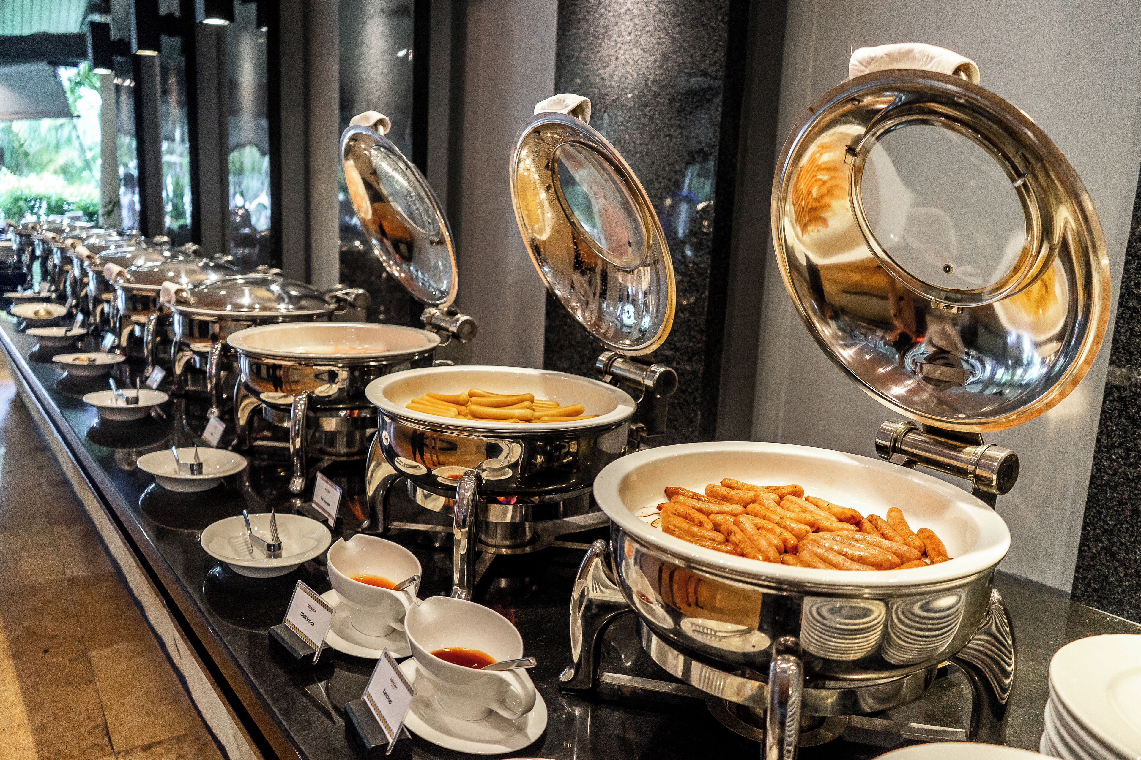 A buffet with various food items and condiments.