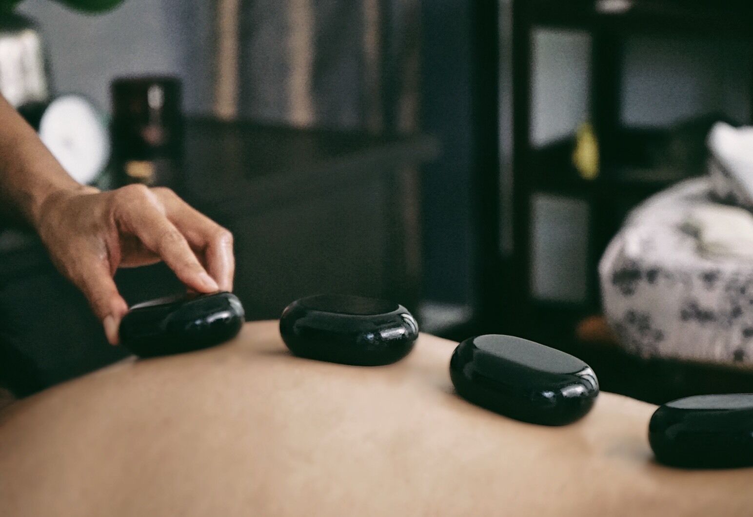 Een hand die een massagetherapieapparaat op iemands rug aanpast.