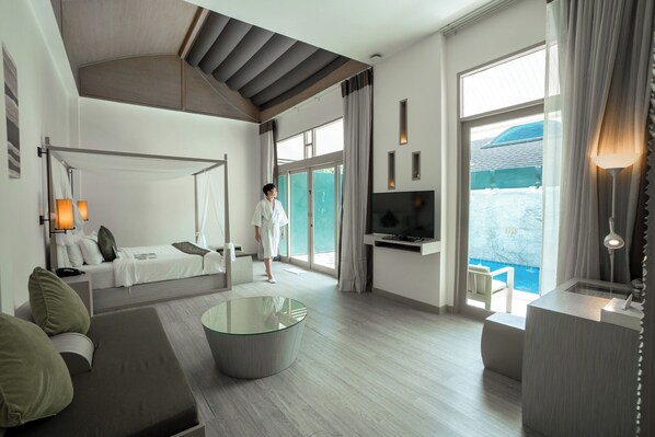 Habitación de hotel moderna con cama, zona de estar, televisor y vista a una piscina.