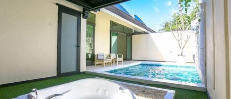 Un área de piscina privada al aire libre con un jacuzzi y una piscina pequeña.