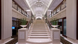A grand, marble-floored staircase with a central chandelier, flanked by glass railings and decorative vases. - Sheraton Changzhou Wujin Hotel (Changzhou)