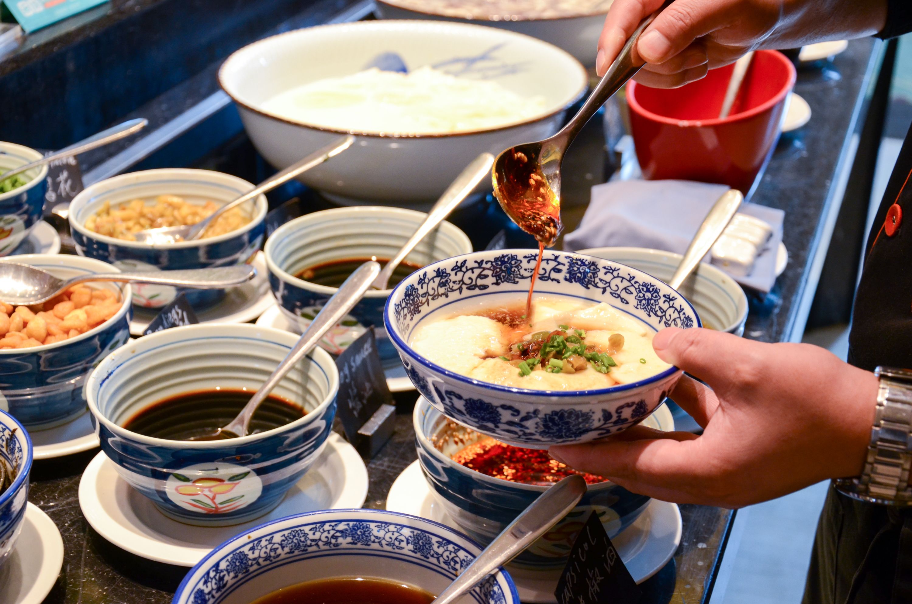A variety of bowls with different sauces and condiments on a table.
