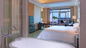 A hotel room with a large bed, a bathroom with a bathtub, a desk, and a television. - Sheraton Changzhou Wujin Hotel (Changzhou)