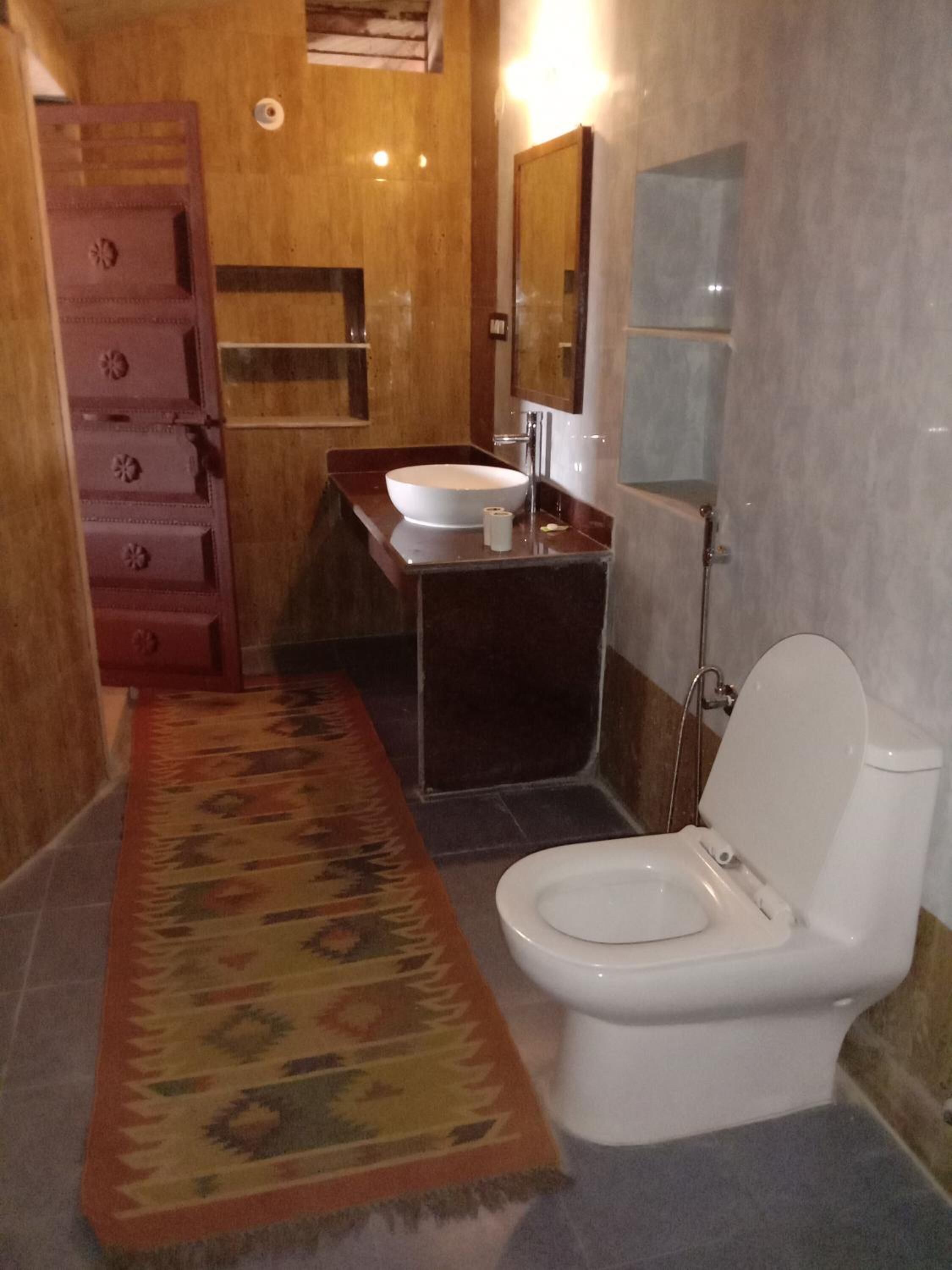 A bathroom with a toilet, sink, and shower.