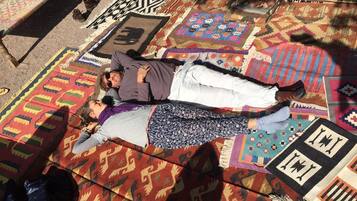 A room with a large, colorful rug featuring various patterns and designs.