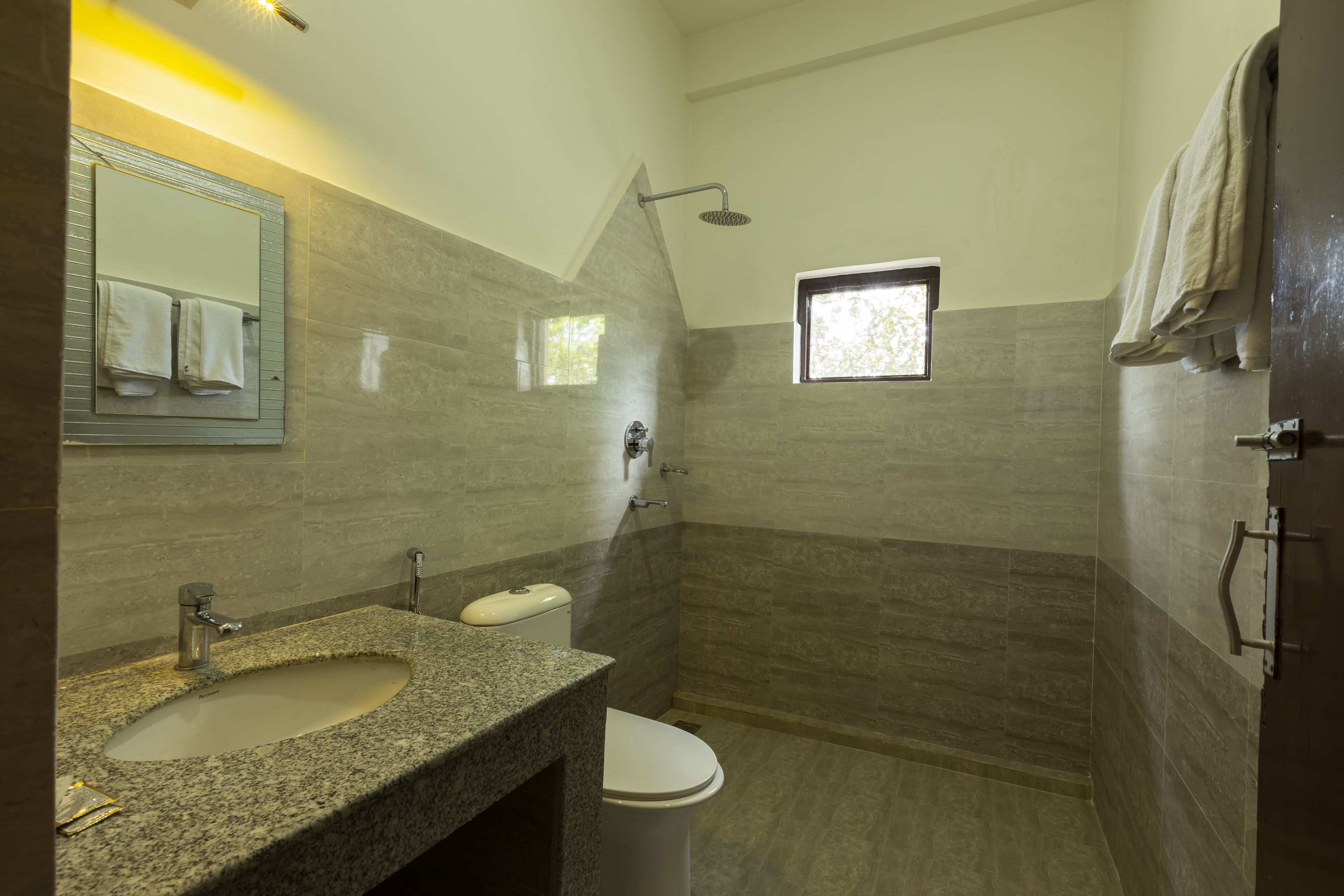 Ein Badezimmer mit einem Granitwaschbecken, einer Toilette und einer Dusche.