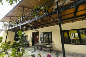 A reception area with a bench and potted plants. - Hotel Parkside & Swimming Pool-Between Greenery and Azure ,Your Perfect Retreat (Sauraha)