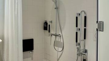 A modern bathroom with a shower, toilet, and a towel rack.
