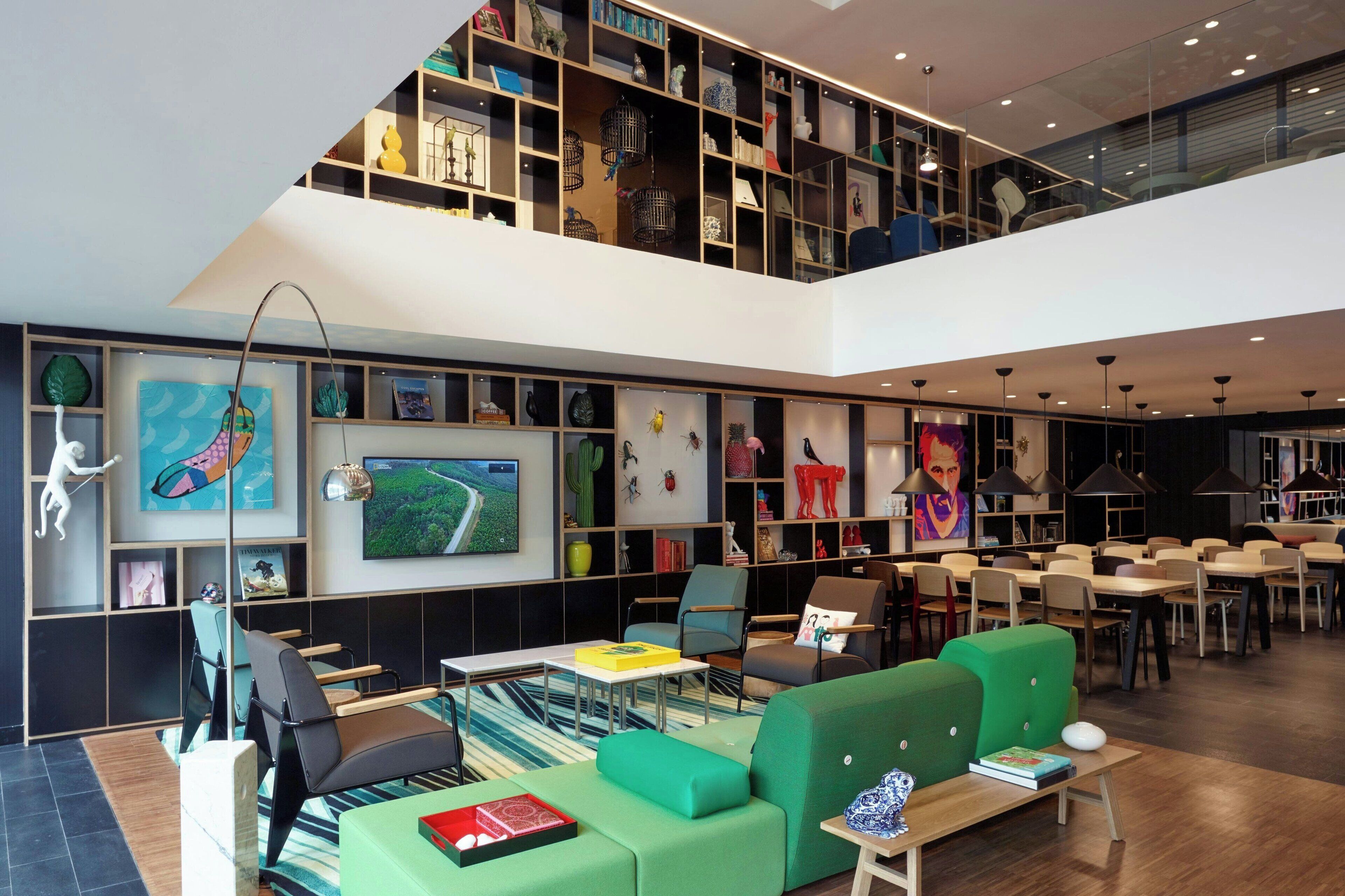 A spacious library with multiple levels, comfortable seating areas, and a variety of books and decorative items.