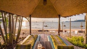 A beachside lounge with thatched roof, wooden benches, and a view of the sea. - Sea Valley Resort (Koh Samui)