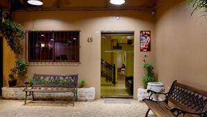 An entrance with a wooden bench, a door marked '49', and a welcome mat.