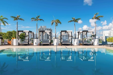 Una piscina al aire libre, camas de piscina con cargo