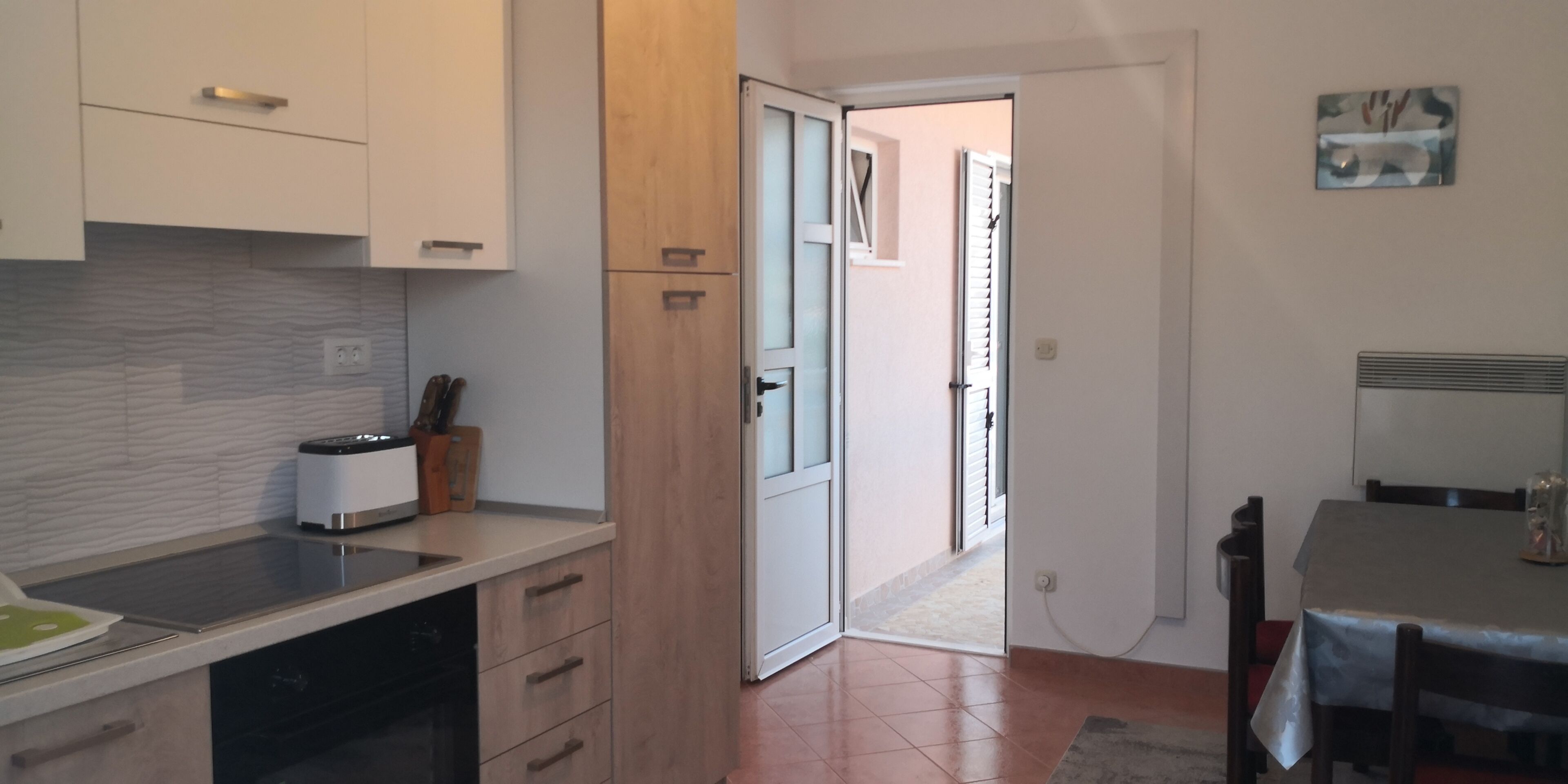 A kitchen with a modern design, featuring a built-in oven, a sink, and wooden cabinets.