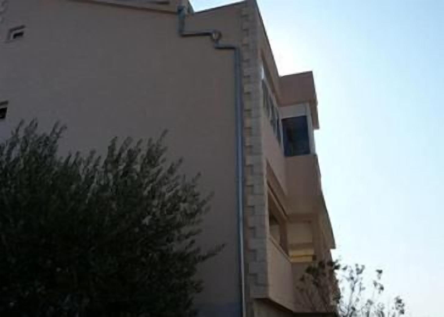 A building with a beige facade and a visible window.