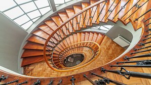 A spiral staircase with wooden steps and metal railings, leading to a lower level. - Hotel Porto Mar (Matosinhos)