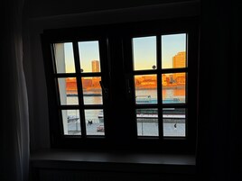 Una ventana con varios cristales que muestra una vista de la ciudad con edificios y un río.