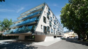 A modern building with a unique angular design, featuring multiple balconies and large windows. - Cityhotel Design & Classic (St. Pölten)