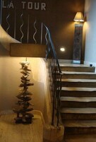 Una escalera con barandilla de metal y una escultura decorativa en la pared.
