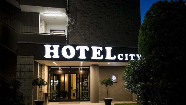 Entrada de un hotel con un cartel llamativo que dice "HOTEL CITY".