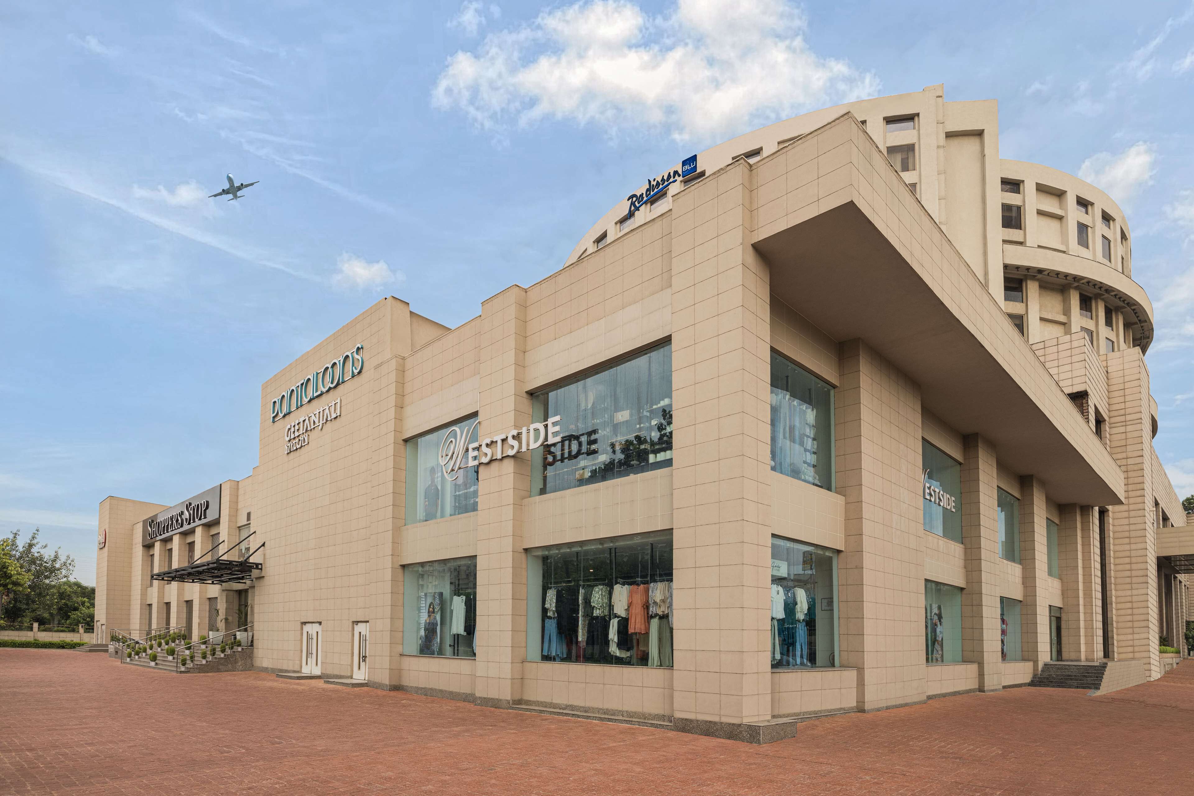 A modern building with a curved facade, large windows, and signage for 'Westside' and 'Potters Stop'.