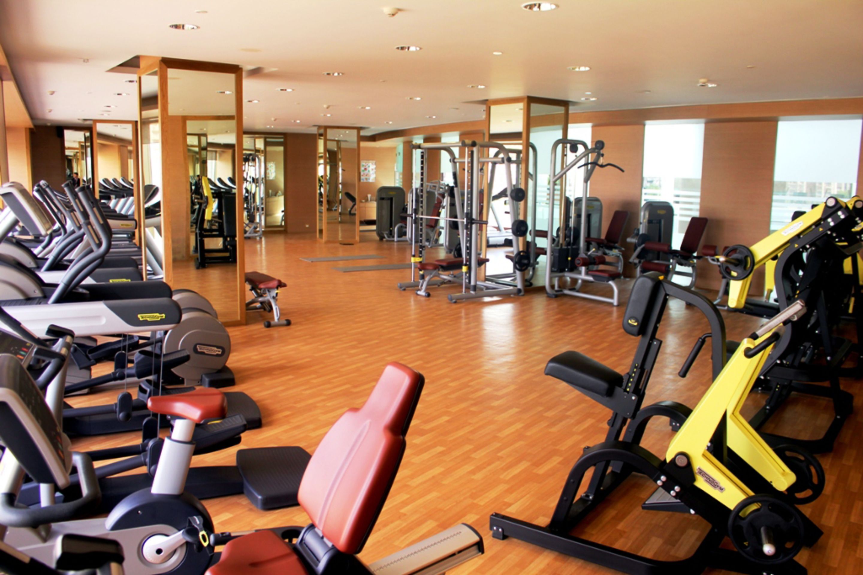 A gym with various exercise equipment, including treadmills, stationary bikes, and weight machines.