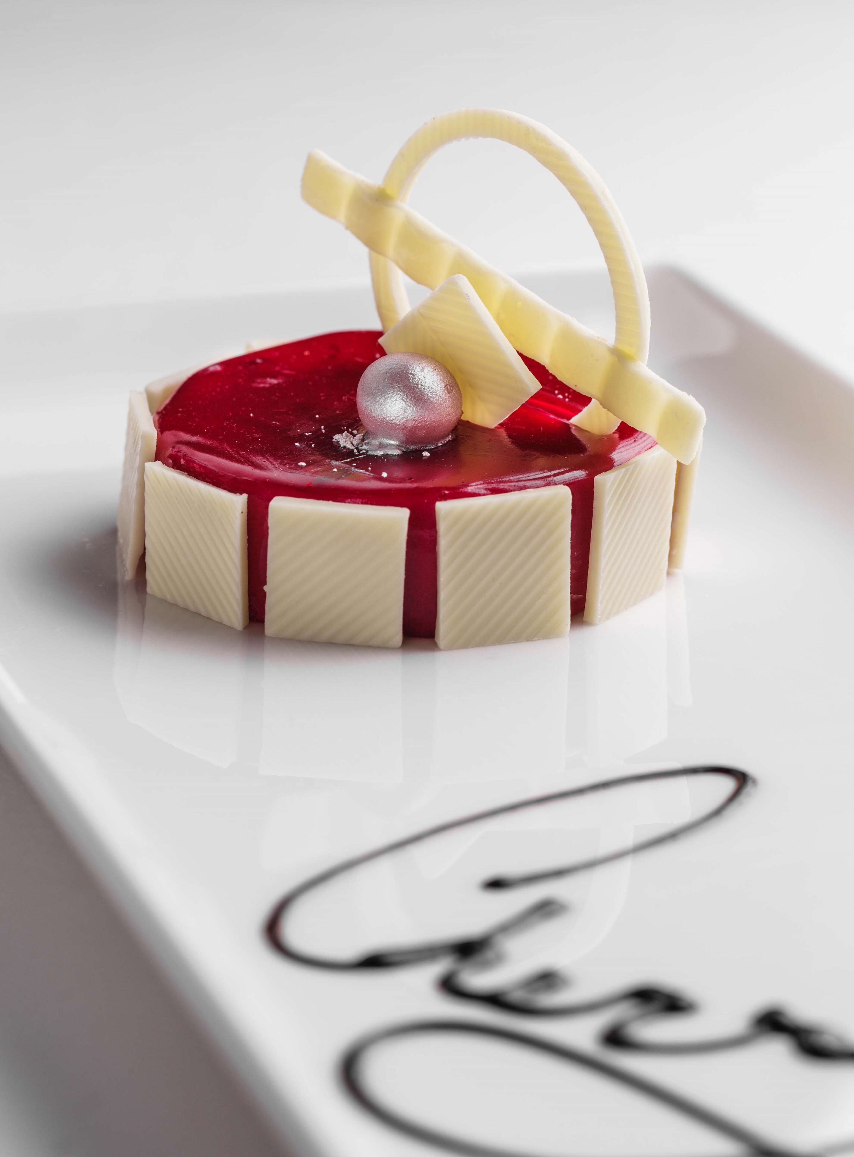 Een dessert op een wit bord met een handtekening.