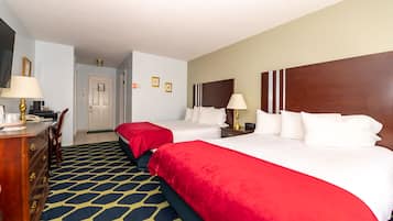 A hotel room with two beds, a desk, and a dresser.