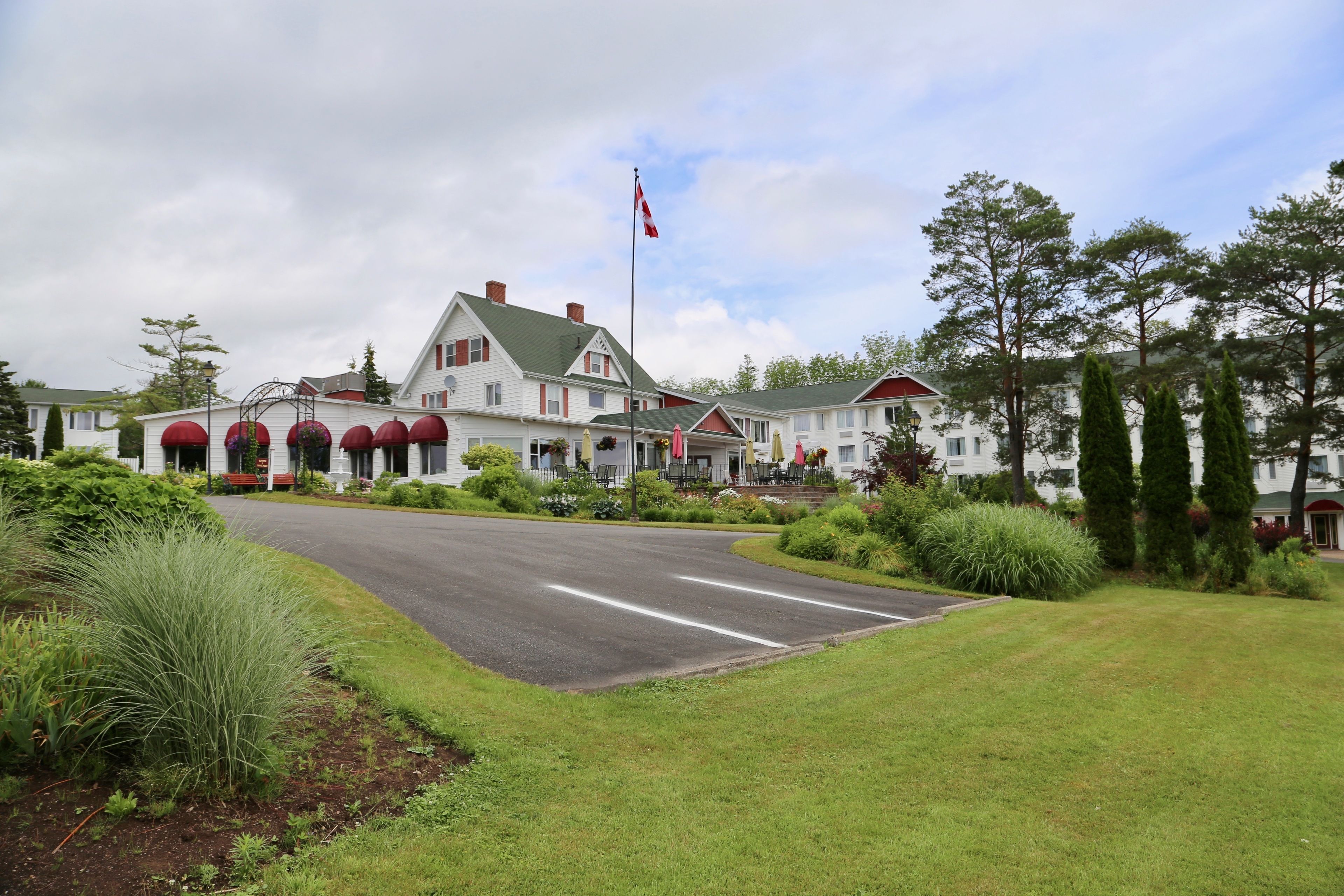 A large, multi-story building with a prominent flag, surrounded by well-maintained lawns and trees.
