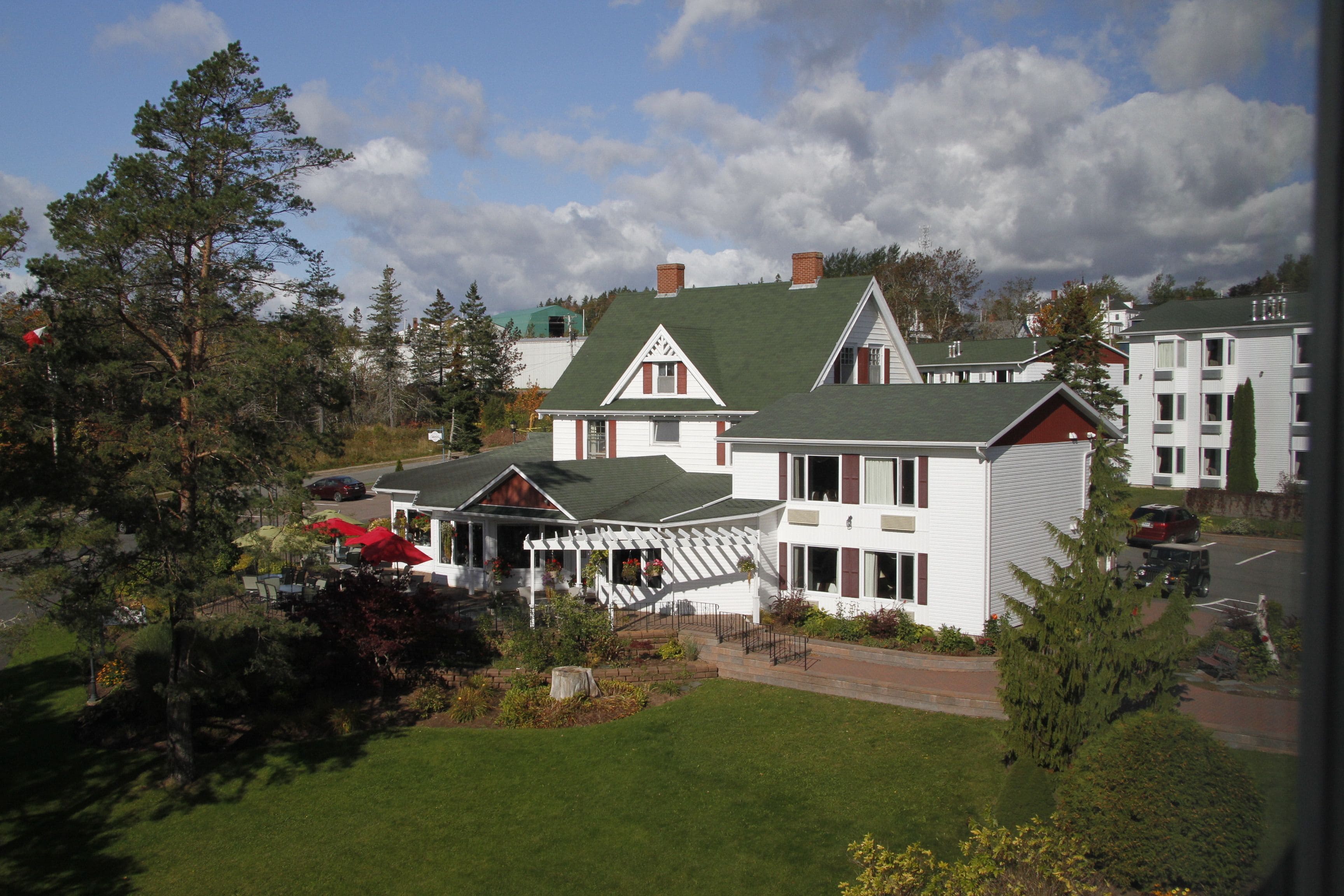 A large white building with a green roof and a covered patio area.