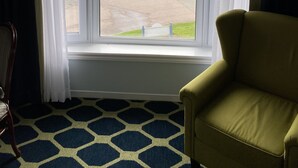 A room with a large window overlooking a parking area and a body of water. - Auberge Gisele's Inn (Baddeck)