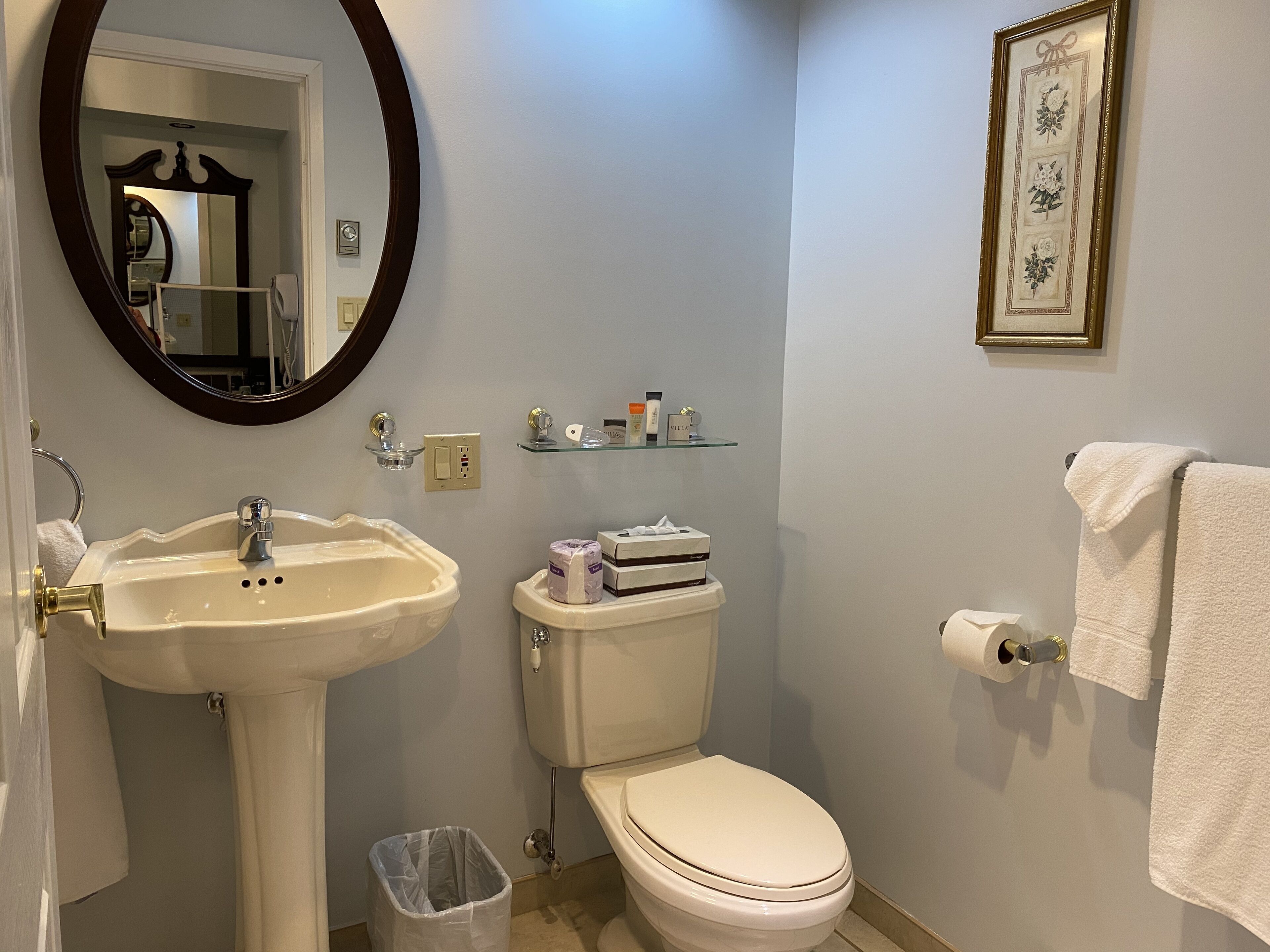 A bathroom with a sink, toilet, and a mirror.
