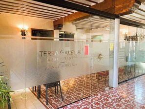 A glass wall with the name 'TERRAGALEGA RESTAURANT' and 'En Hotel A POSADA' written on it.
