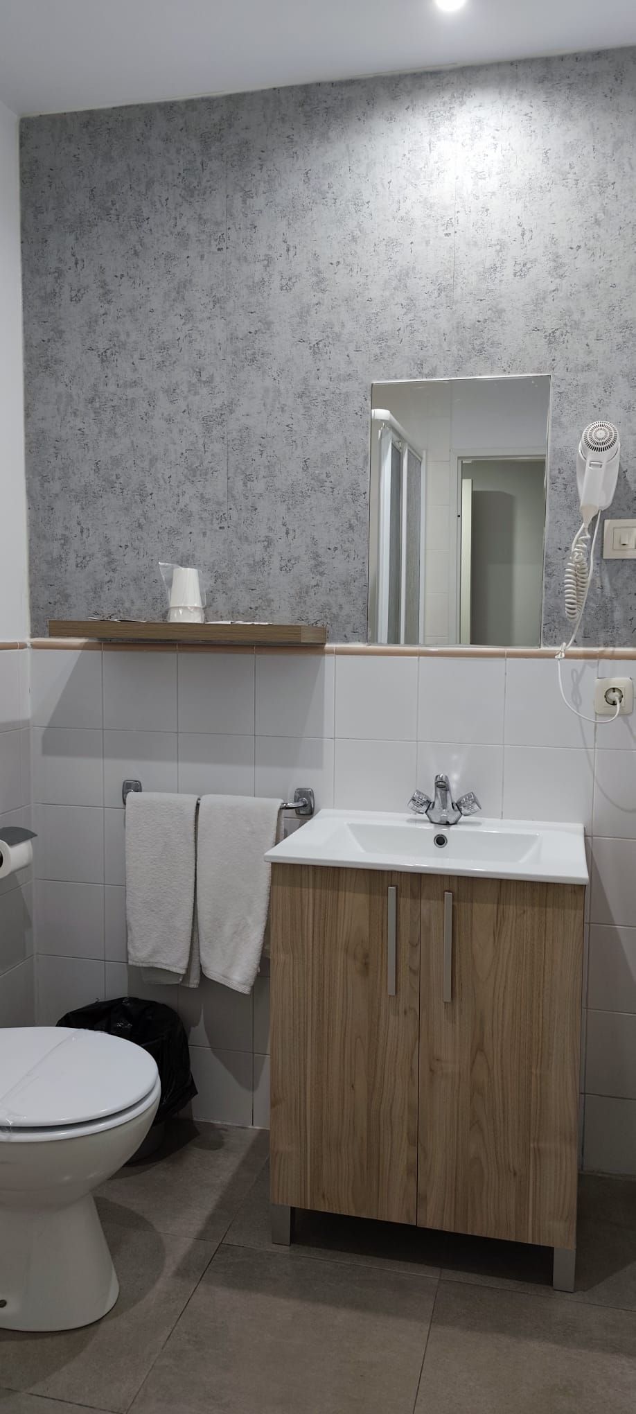Un baño con inodoro, lavabo y espejo.