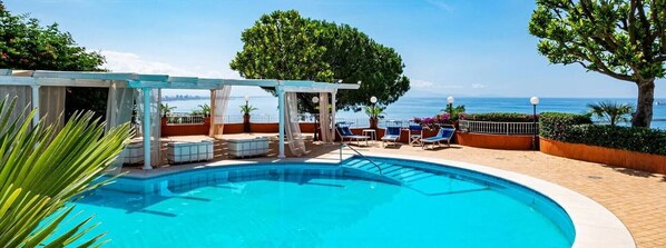 A pool area with a view of the sea, a covered seating area, and potted plants. - Villa Poseidon Boutique Hotel & Events (Salerno)