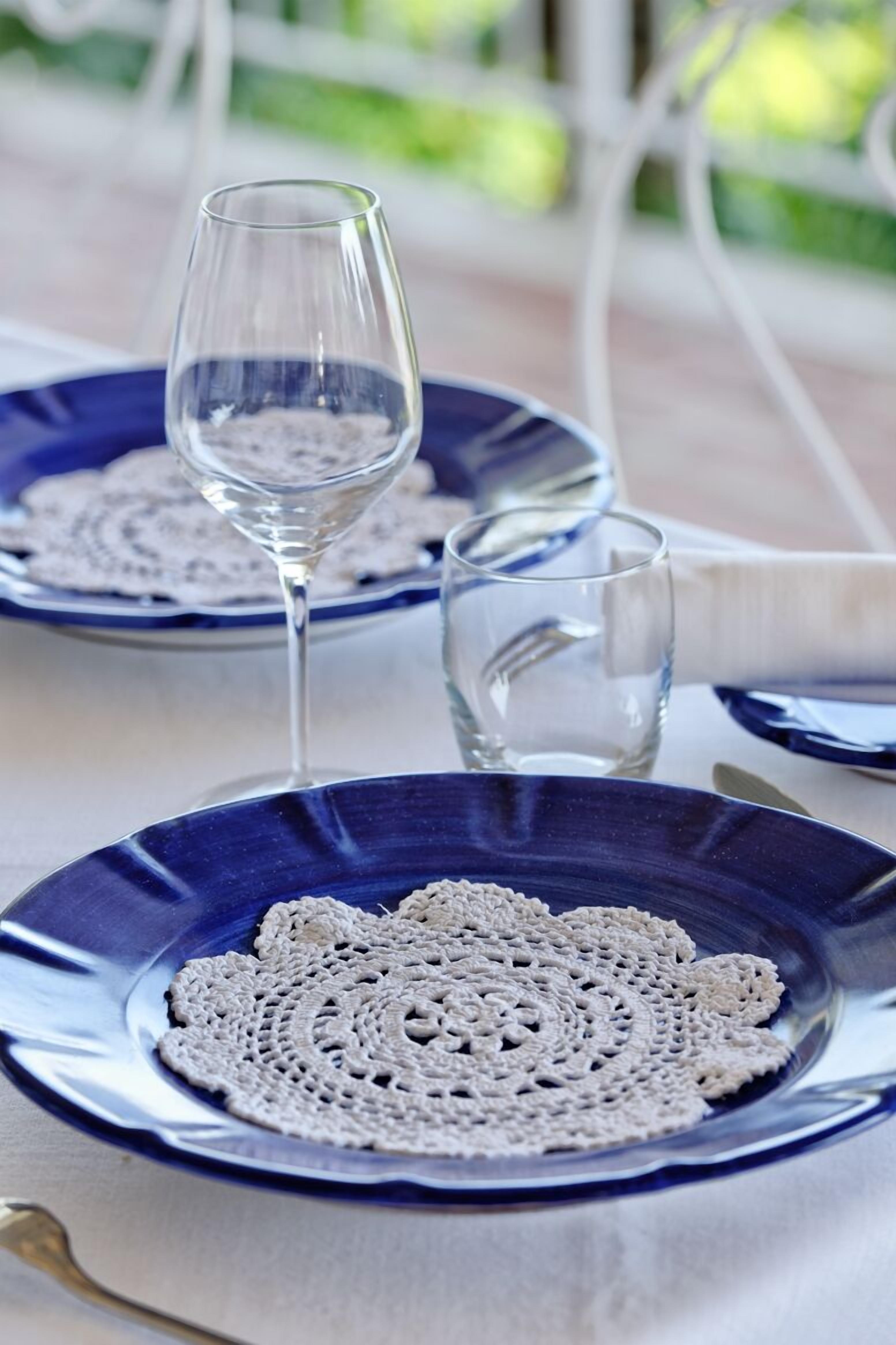 A table with blue plates, a clear glass, and a glass of water.