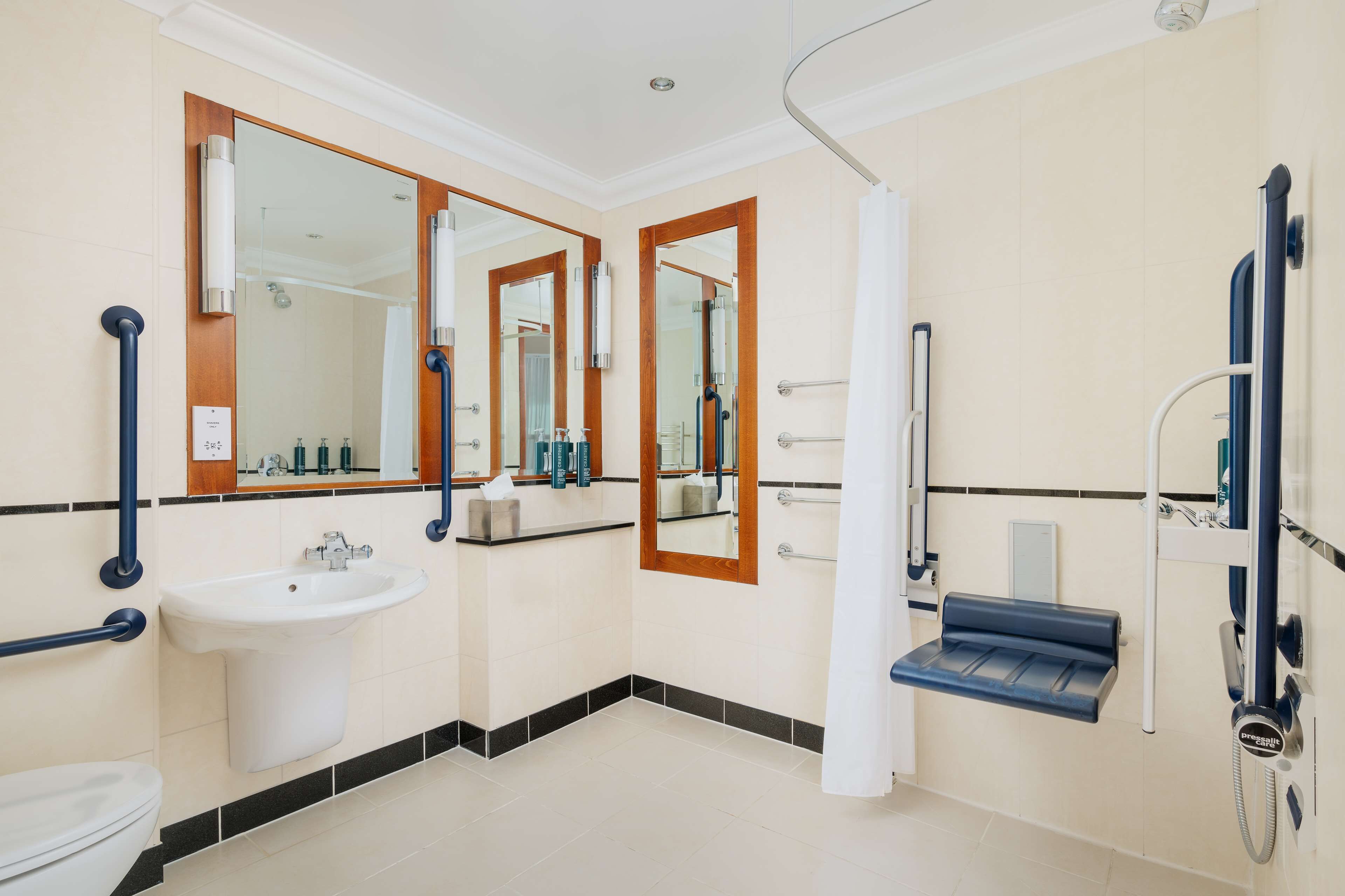 A modern bathroom with a sink, mirror, and shower.