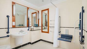 A modern bathroom with a sink, mirror, and shower.