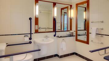 Un baño moderno con inodoro, lavamanos y espejos.