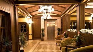 A spacious lobby with a high ceiling, a central chandelier, and a large mirror reflecting the room. - Padok Premium Hotel and Stables (Ula)