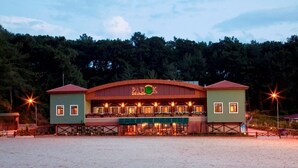 A large, single-story building with a curved roof and a central entrance. - Padok Premium Hotel and Stables (Ula)