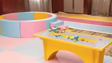 A play area with a yellow table and colorful blocks.