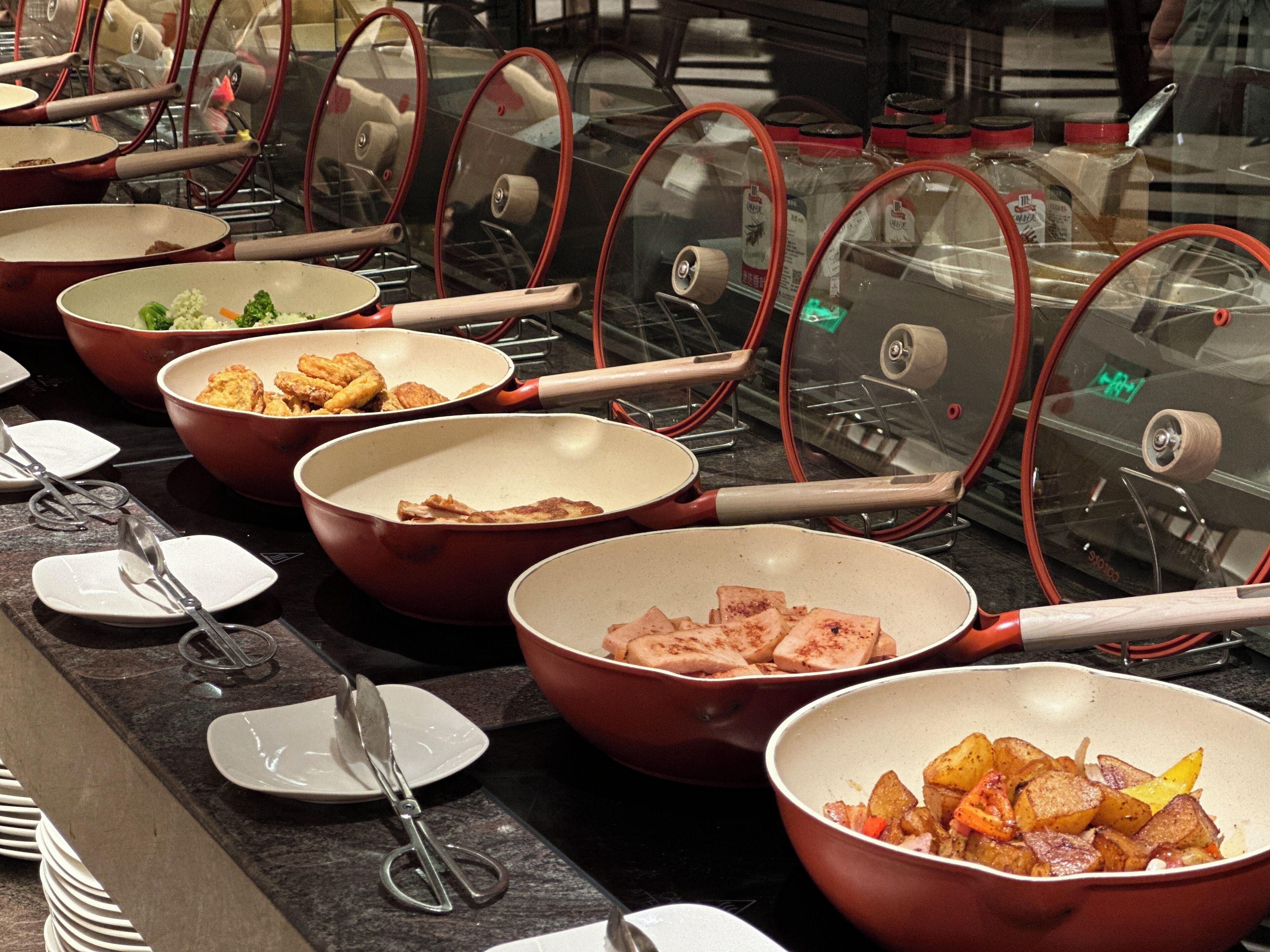 Un buffet avec de nombreux plats et ustensiles de service.