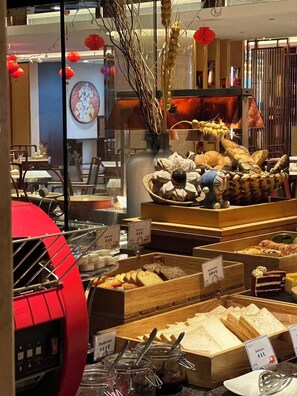 Mostrador de panadería con diversos productos horneados y una máquina de café.