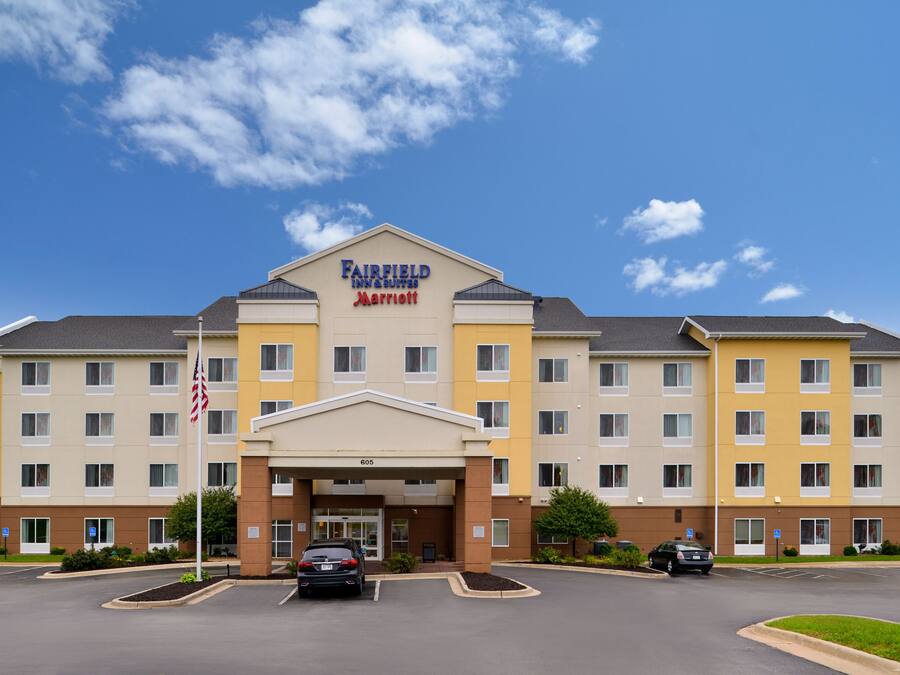 A Fairfield Inn & Suites by Marriott hotel with a central entrance, multiple floors, and a parking lot.