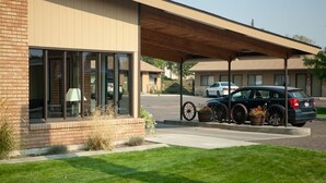 A modern building with large windows and a covered parking area. - Oregon Trail Inn (Buhl)