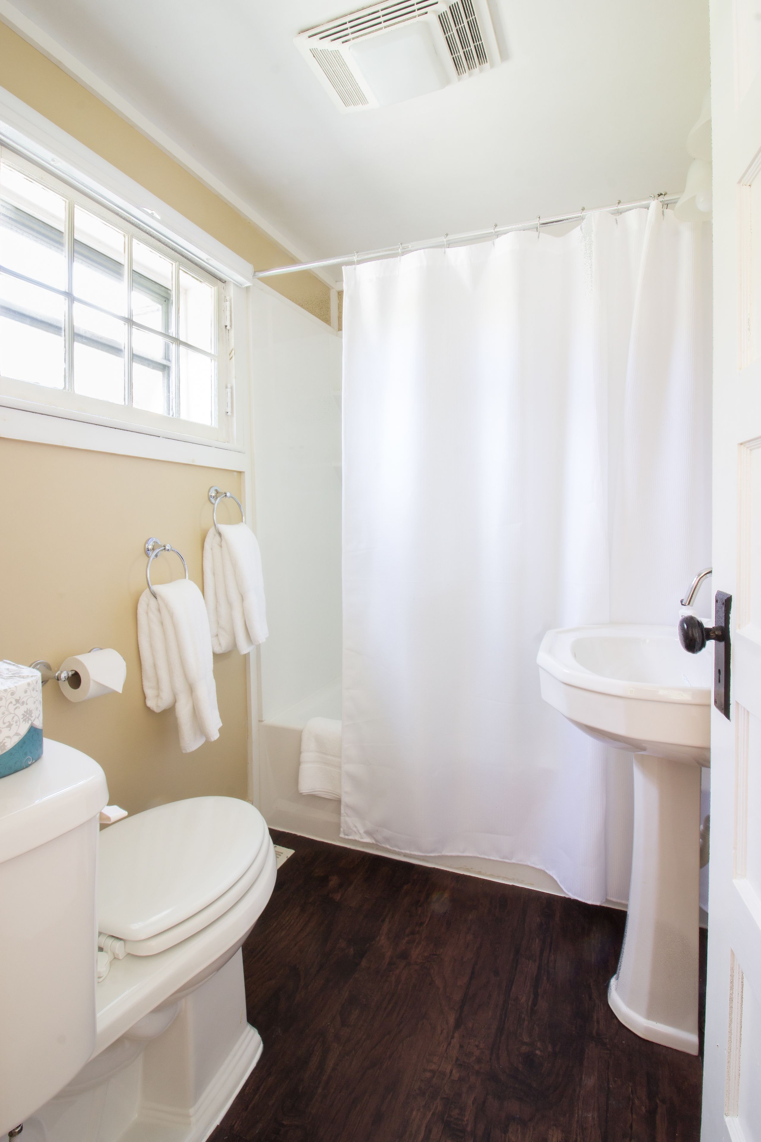 Un baño con inodoro, lavabo y cortina de ducha.