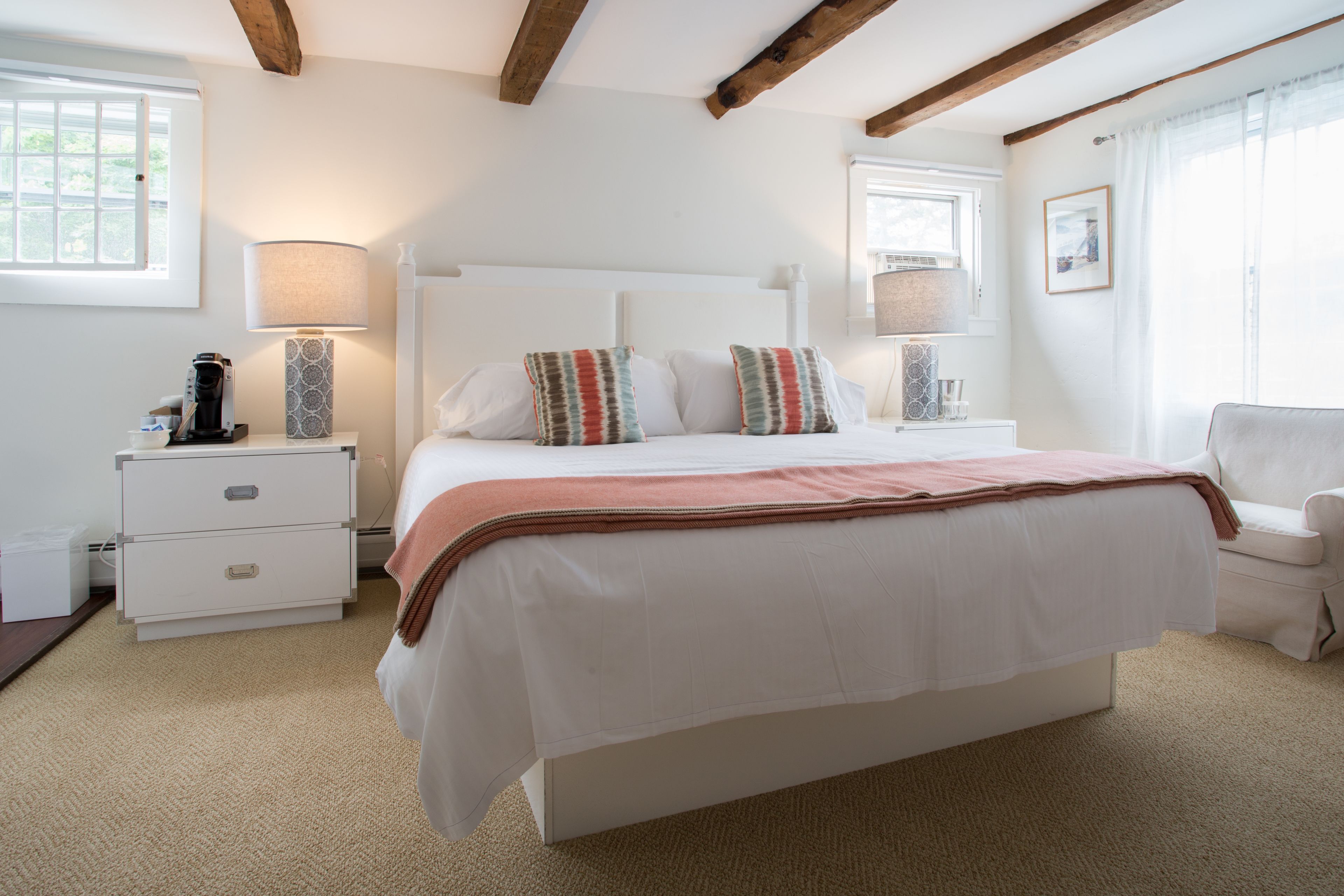 A bedroom with a large bed, bedside tables, a lamp, and a chair.