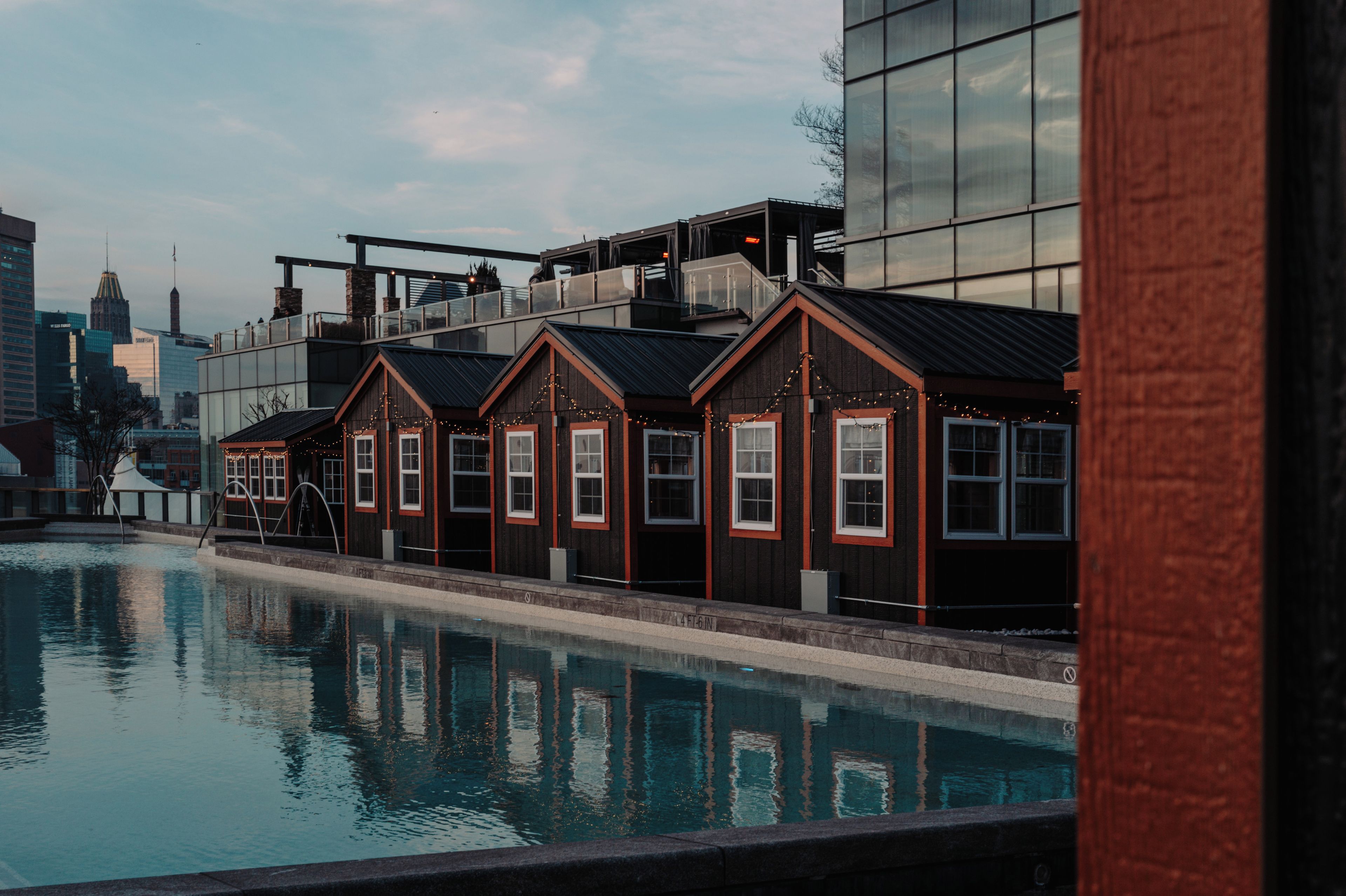 A modern building with a glass facade and a pool area.